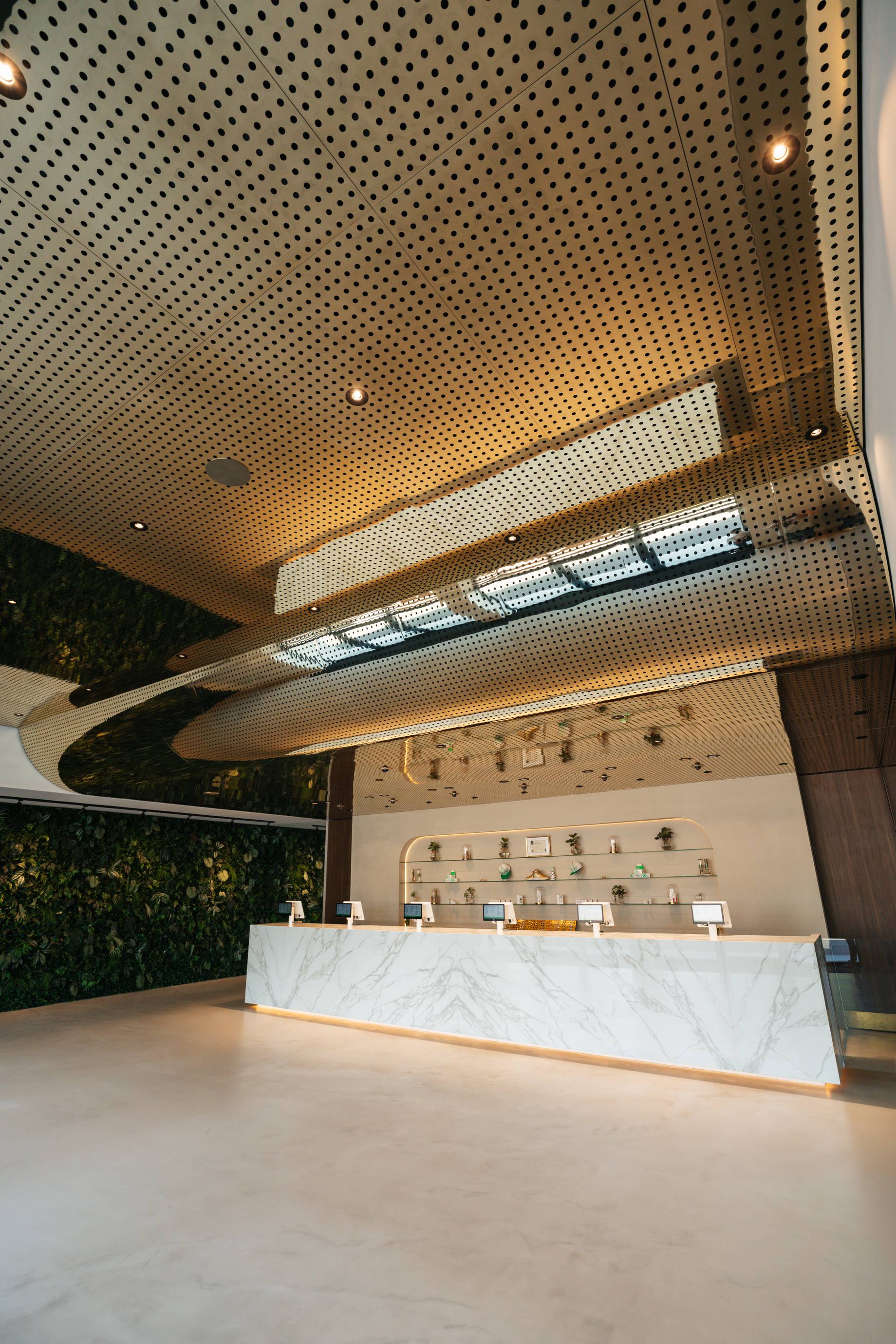 De Loods Amersfoort service counter with living wall and gold ceiling